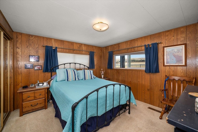 bedroom featuring wood walls and light colored carpet