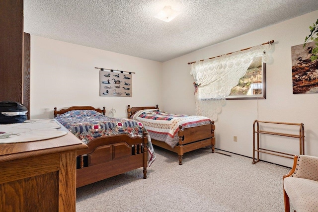 bedroom featuring light carpet and a textured ceiling