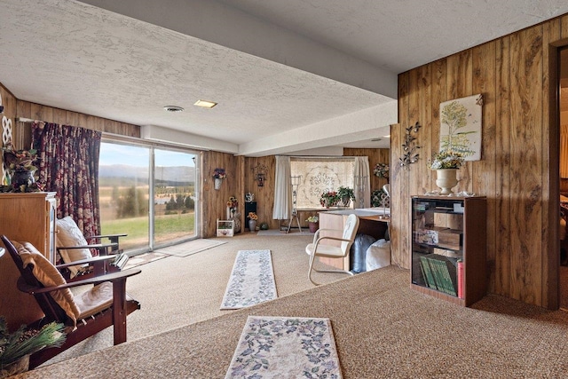 interior space featuring wooden walls, visible vents, carpet, and a textured ceiling