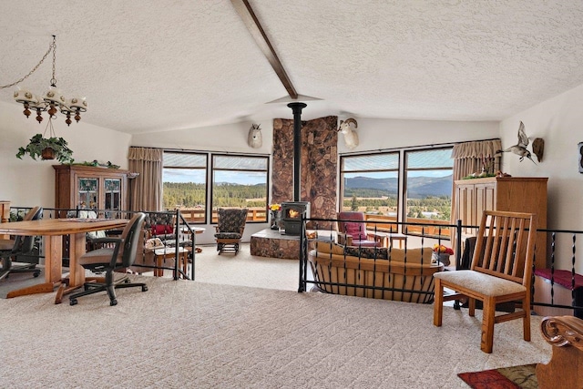 office space featuring a wood stove, carpet flooring, a textured ceiling, and lofted ceiling with beams