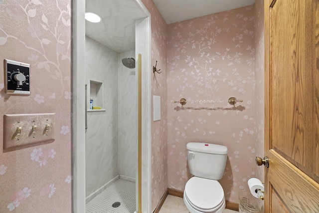 bathroom featuring a shower, tile patterned floors, and toilet