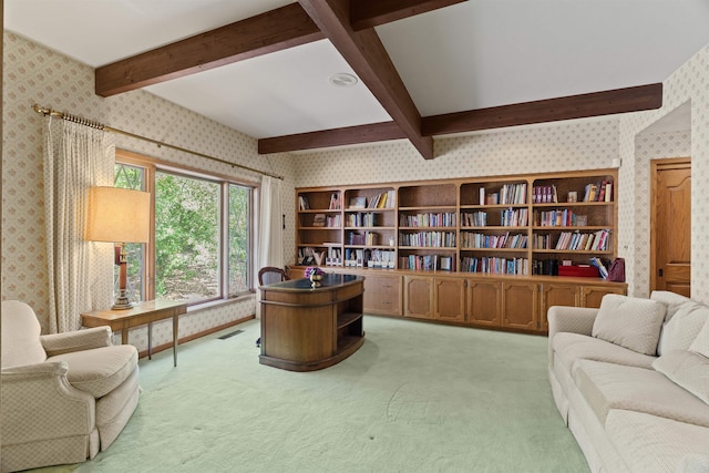 carpeted office featuring beamed ceiling