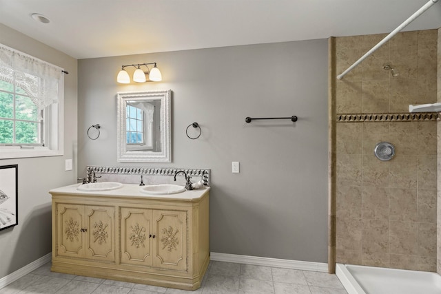 bathroom featuring tile patterned flooring, vanity, and a tile shower