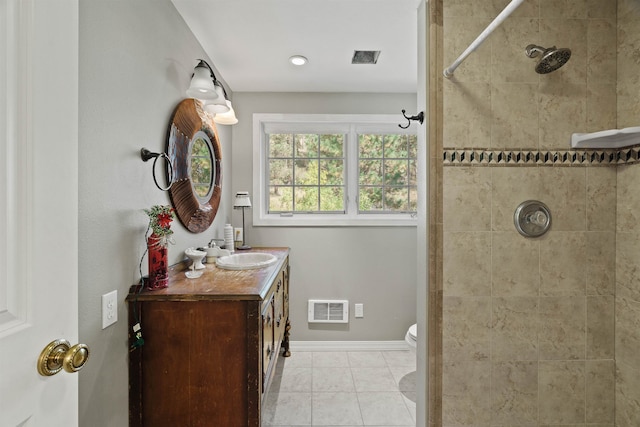 bathroom featuring a tile shower, tile patterned flooring, vanity, and toilet