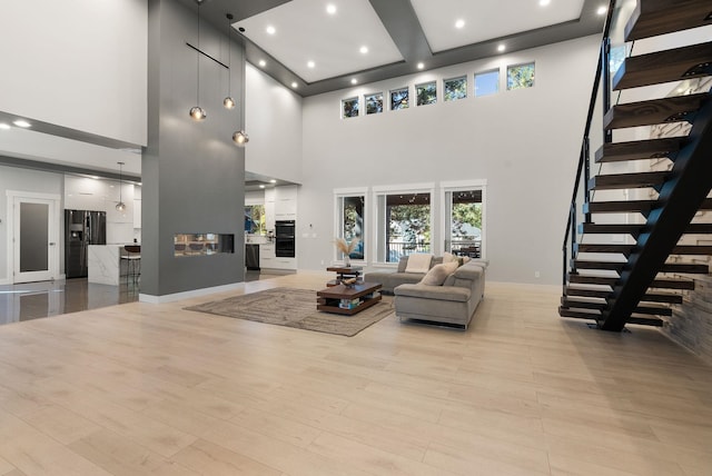 living room with light hardwood / wood-style flooring and a high ceiling