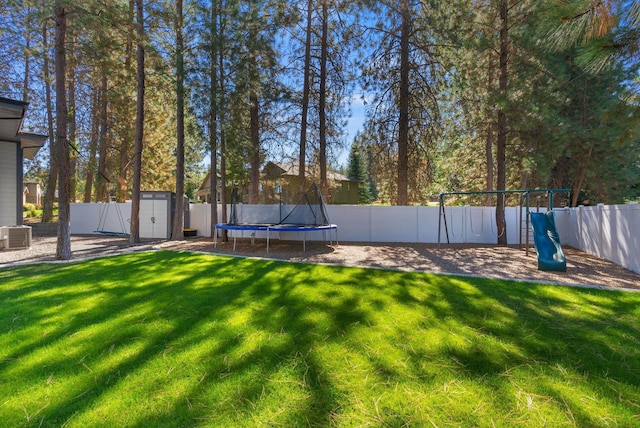 rear view of house with central AC, a deck, and a lawn