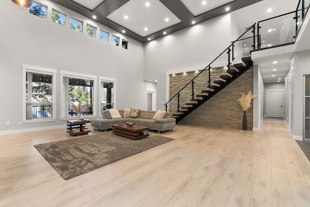 living room with light hardwood / wood-style floors and a high ceiling