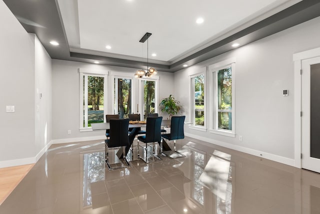 dining space with plenty of natural light, tile patterned floors, and a raised ceiling