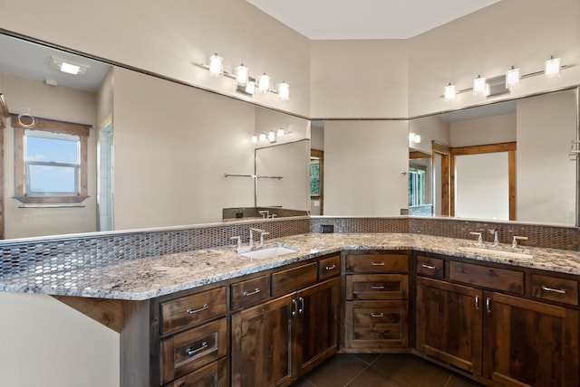 bathroom with double vanity, a sink, and tile patterned floors
