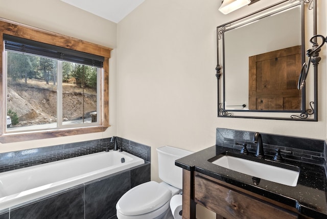 bathroom with vanity, toilet, and a relaxing tiled tub