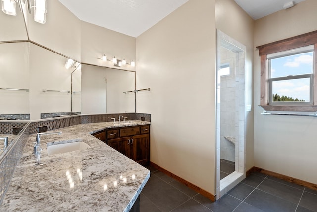 bathroom featuring a tile shower, tile patterned flooring, and vanity