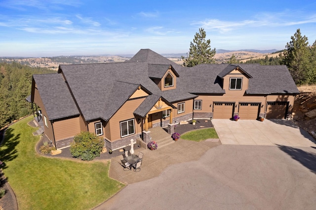 craftsman inspired home with concrete driveway, a shingled roof, a front lawn, and stone siding