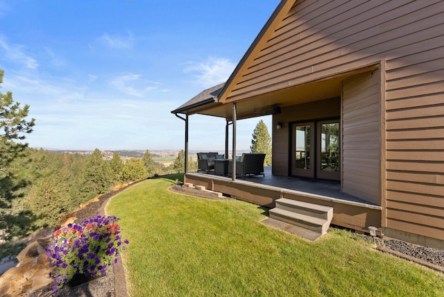 view of yard with a deck and french doors