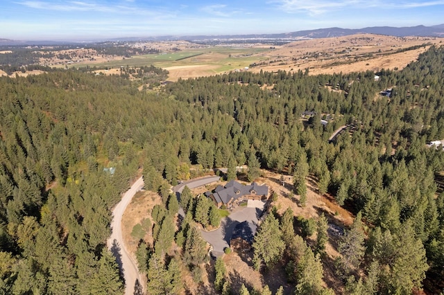 birds eye view of property with a mountain view and a forest view