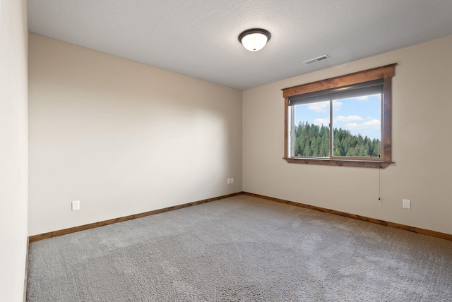 carpeted empty room featuring visible vents and baseboards
