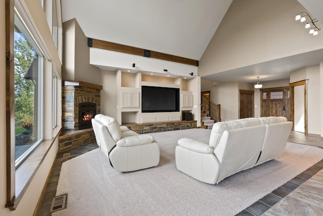 living area with a fireplace, stairway, visible vents, and high vaulted ceiling
