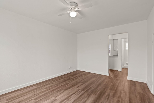 unfurnished bedroom with ceiling fan, ensuite bathroom, and hardwood / wood-style floors