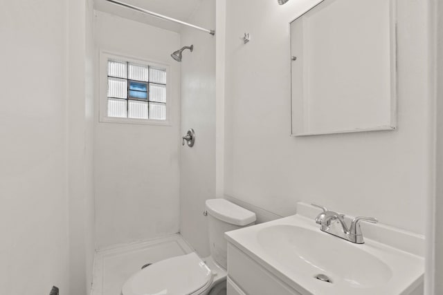 bathroom with walk in shower, vanity, and toilet