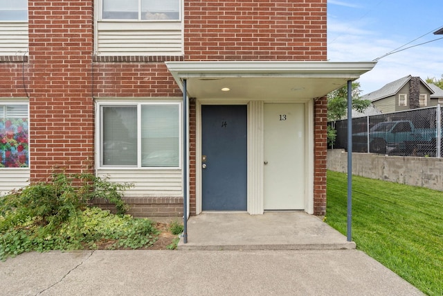 view of exterior entry featuring a yard