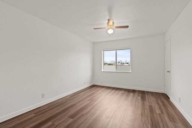 empty room featuring ceiling fan and dark hardwood / wood-style flooring