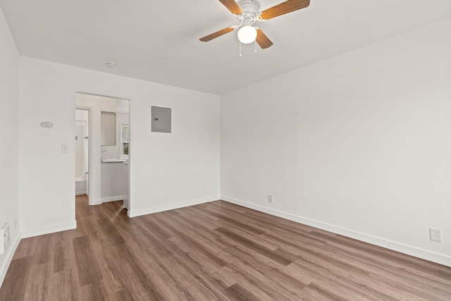 unfurnished room with ceiling fan, electric panel, and hardwood / wood-style floors