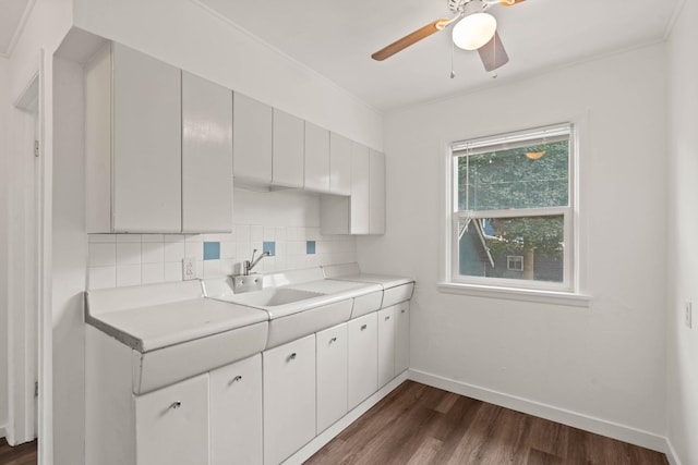 kitchen featuring dark hardwood / wood-style floors, sink, white cabinetry, decorative backsplash, and ceiling fan