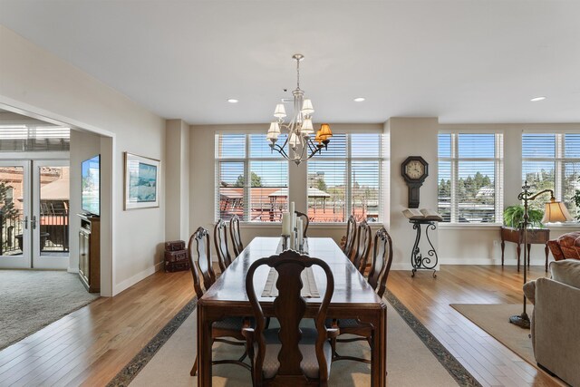 820 N Post St Unit 106, Spokane, WA 99201 - dining room featuring baseboards, a notable chandelier, hardwood / wood-style floors, and a wealth of natural light