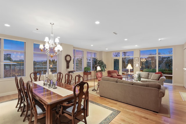 dining space with a notable chandelier and light hardwood / wood-style flooring