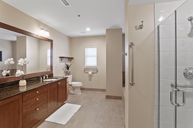 bathroom with tile patterned flooring, vanity, toilet, and a shower with shower door