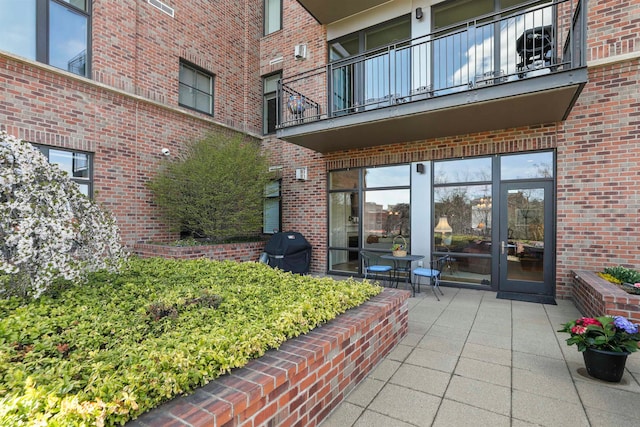 property entrance featuring a balcony, french doors, and a patio area