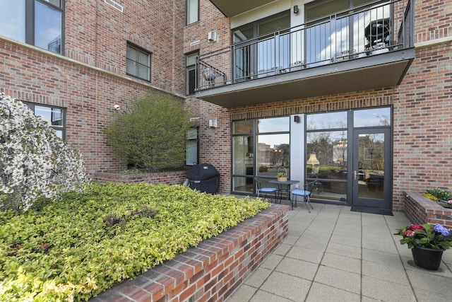 820 N Post St Unit 106, Spokane, WA 99201 - view of exterior entry featuring a patio, brick siding, and a balcony