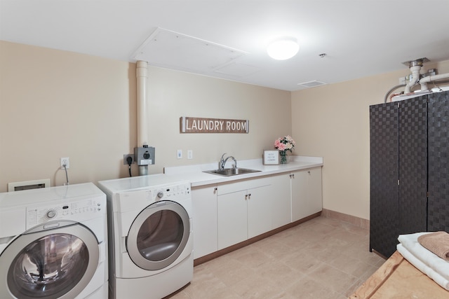 laundry room featuring washing machine and clothes dryer, cabinets, and sink