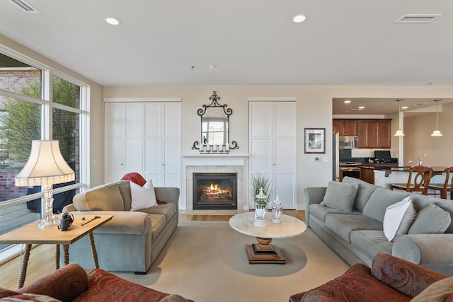 living room featuring light wood-type flooring and a tile fireplace