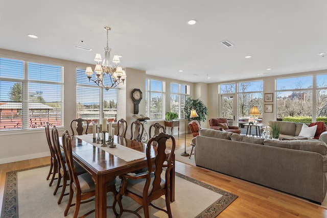 dining room with an inviting chandelier, light wood-type flooring, and plenty of natural light