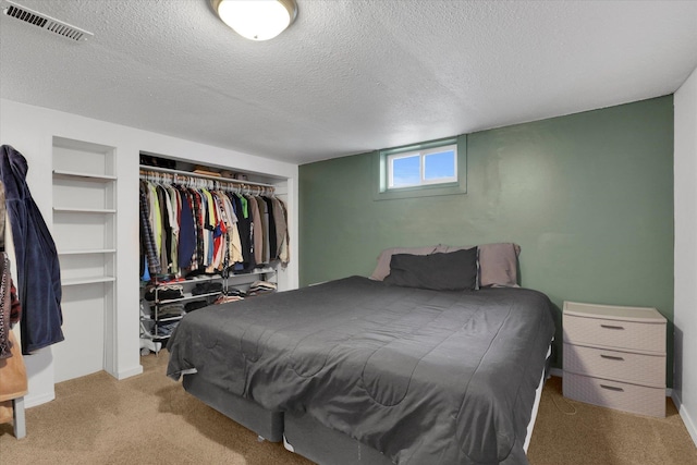 carpeted bedroom with a closet and a textured ceiling