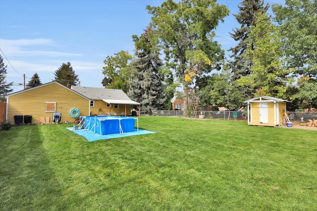 view of yard with a storage unit and a fenced in pool