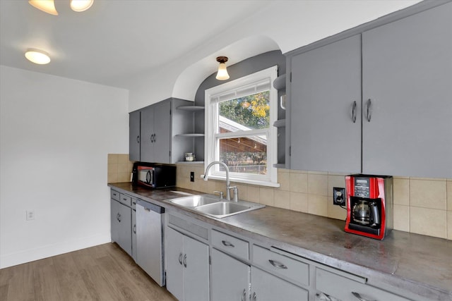 kitchen with gray cabinetry, dishwasher, light hardwood / wood-style flooring, and decorative backsplash