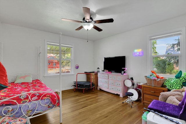 bedroom with wood-type flooring, ceiling fan, and multiple windows