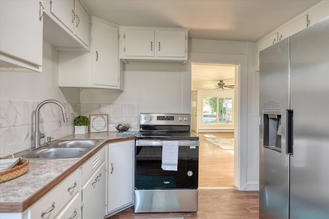 kitchen with white cabinetry, stainless steel appliances, ceiling fan, hardwood / wood-style floors, and sink