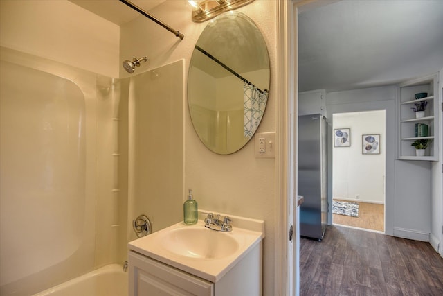 bathroom with bathtub / shower combination, hardwood / wood-style flooring, and vanity