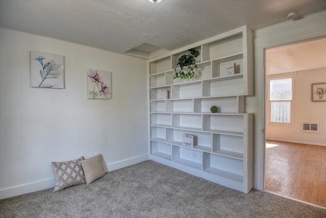 interior space with a textured ceiling and hardwood / wood-style floors