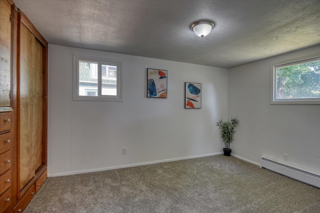 empty room featuring carpet floors, a textured ceiling, and a healthy amount of sunlight