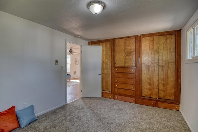 unfurnished bedroom with a textured ceiling and light colored carpet