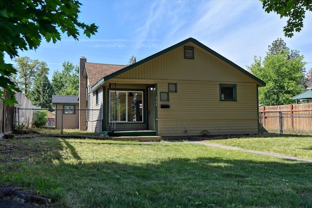 rear view of property featuring a yard