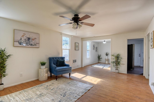 living area featuring ceiling fan and light hardwood / wood-style flooring