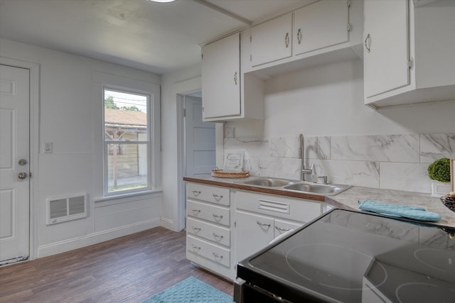 kitchen with dark hardwood / wood-style flooring, white cabinets, electric stove, and sink