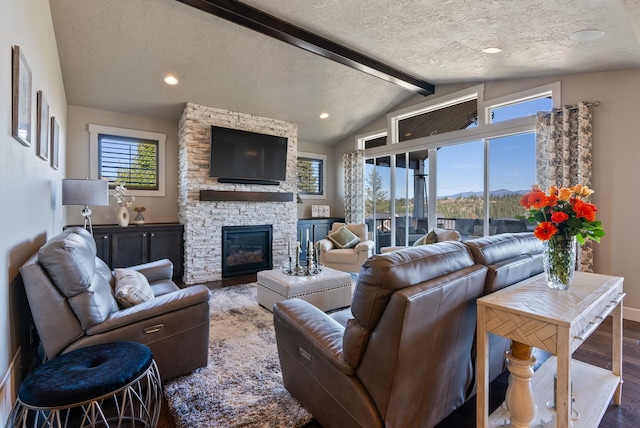 living room featuring a textured ceiling, vaulted ceiling with beams, a fireplace, and hardwood / wood-style flooring