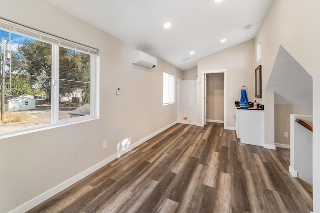 2213 E E Gordon Ave, Spokane, WA 99207 - unfurnished living room featuring an AC wall unit, healthy amount of natural light, dark wood-style floors, lofted ceiling, and baseboards