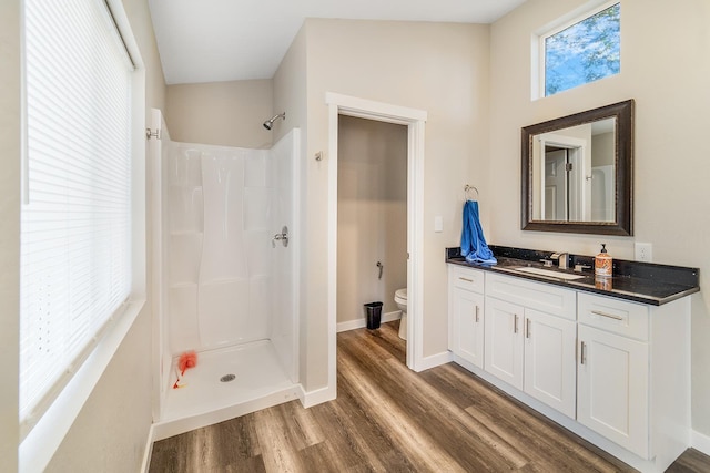 2213 E E Gordon Ave, Spokane, WA 99207 - full bathroom featuring wood finished floors, toilet, a shower, vanity, and baseboards