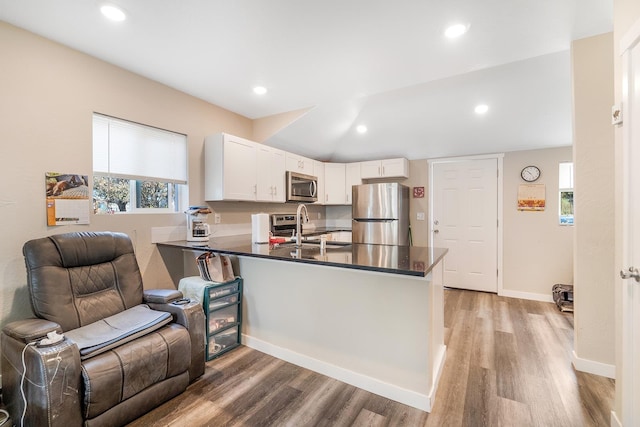2213 E E Gordon Ave, Spokane, WA 99207 - kitchen featuring stainless steel appliances, open floor plan, dark countertops, a peninsula, and light wood-style floors